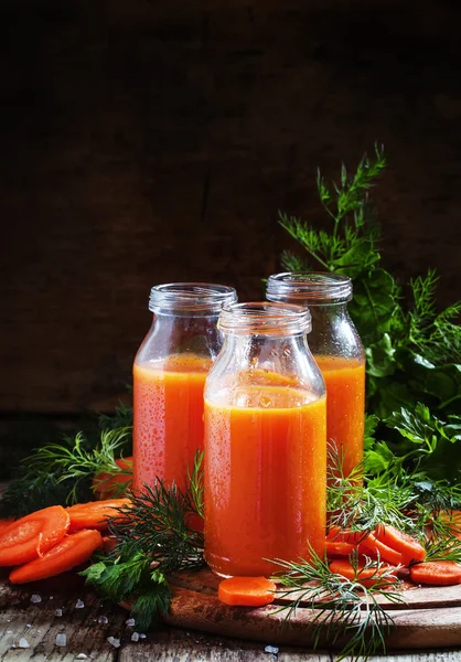 Frisch gepresster Saft von Karotten in Glasflaschen — Stockfoto