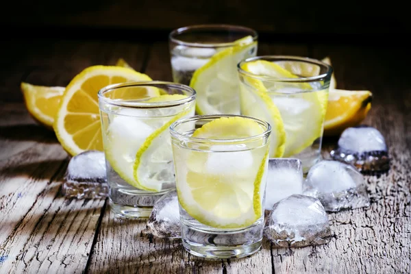 Холодная русская водка с лимоном и льдом в рюмках — стоковое фото