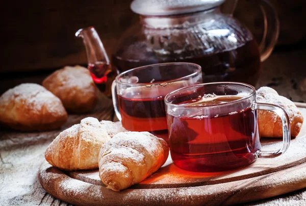 Té negro de Ceilán en tazas de vidrio con hervidor de agua, cruasanes frescos —  Fotos de Stock