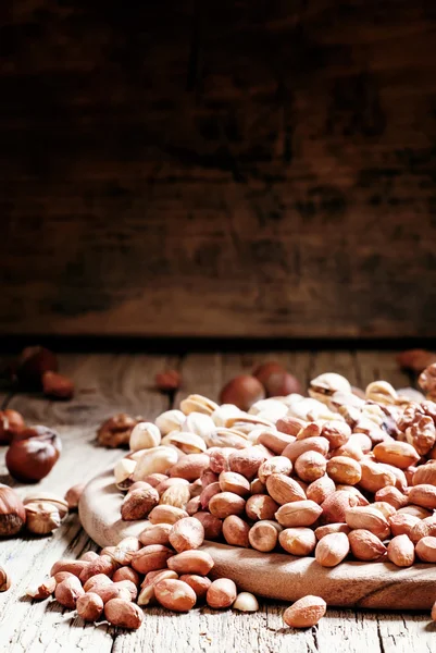 Kacang tumpah, latar belakang gelap kayu. — Stok Foto