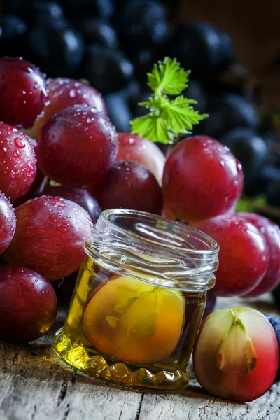 Esszenciális olaj, szőlőmag, és egy friss virágcsokor szőlő — Stock Fotó