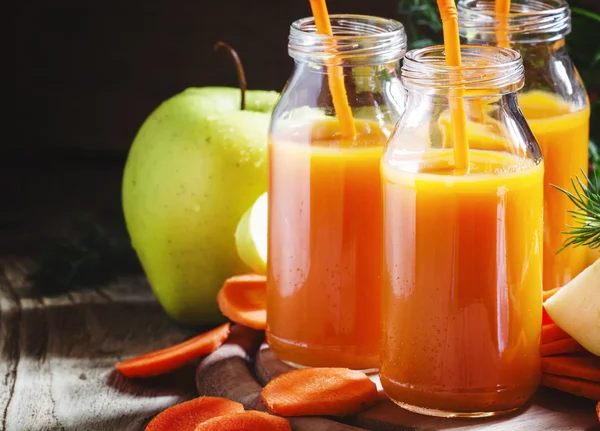 Lichotník jablko mrkev do skleněných lahví — Stock fotografie