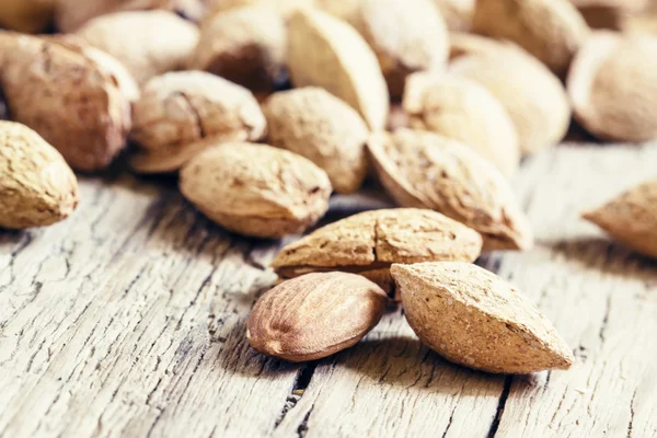 Salted almonds in shell on a vintage wooden background