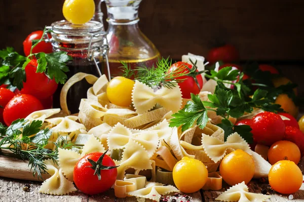 Farfalle massas, salsa e especiarias, tomates cereja vermelhos e amarelos — Fotografia de Stock