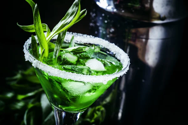 Green alcoholic cocktail with ice in a martini glass — Stock Photo, Image
