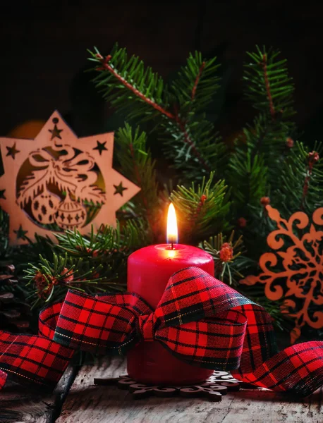 Christmas composition with burning red candle with plaid ribbon — Stock Photo, Image