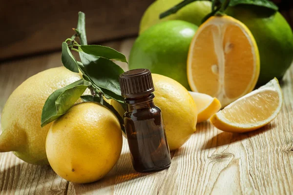 Olio essenziale di limone e limoni freschi — Foto Stock