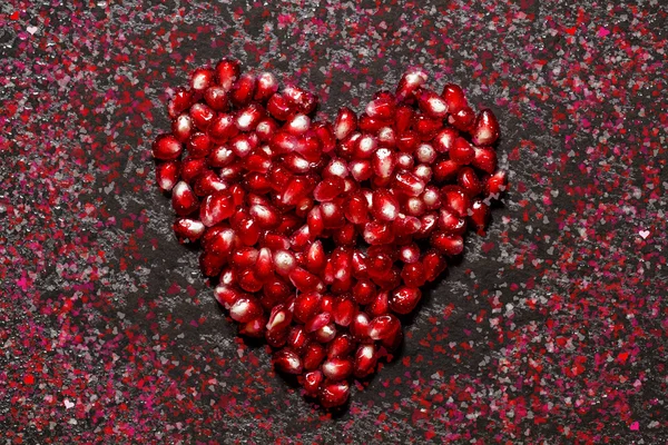 Composition for Valentine's Day with pomegranate seeds and paint — Stock Photo, Image