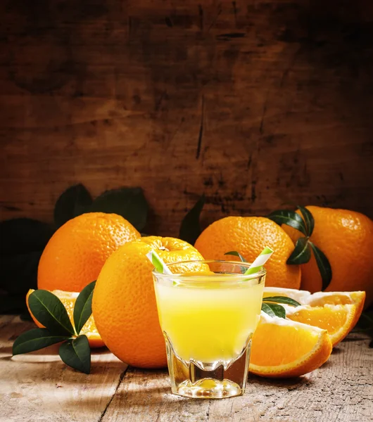 Orange juice in a glass with striped straws — Stock Photo, Image