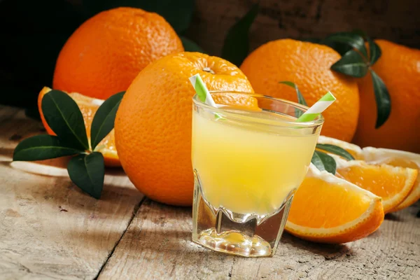 Orange juice in a glass with striped straws — Stock Photo, Image