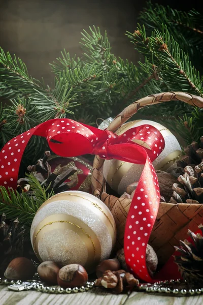 Cesta de vime com bolas de Natal e pinhas — Fotografia de Stock