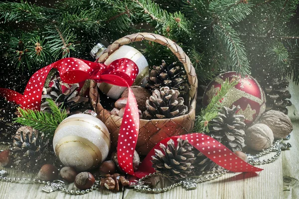 Cesta de vime com bolas de Natal e pinhas — Fotografia de Stock