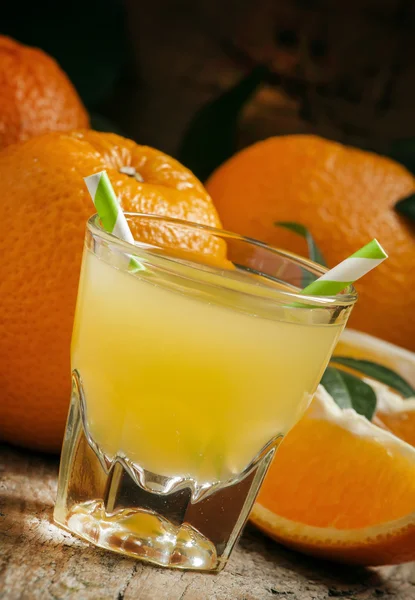 Sumo de laranja em um copo com palhas listradas — Fotografia de Stock