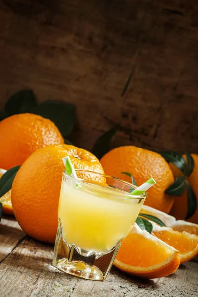 Pomerančová šťáva ve sklenici s proužkované slámou — Stock fotografie