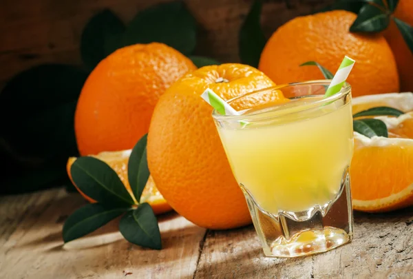 Orange juice in a glass with striped straws — Stock Photo, Image