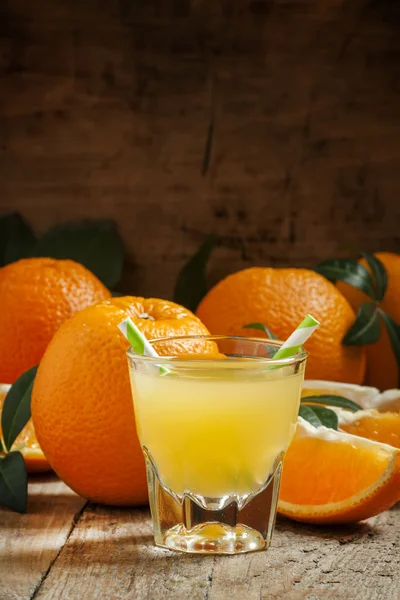 Orange juice in a glass with striped straws — Stock Photo, Image