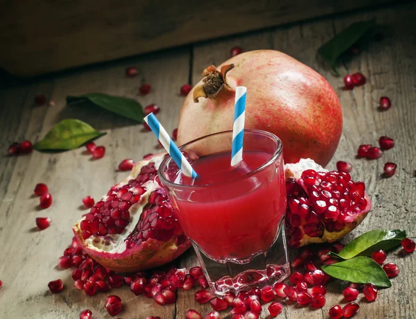 Гранатний коктейль у великій склянці зі смугастими соломинками — стокове фото