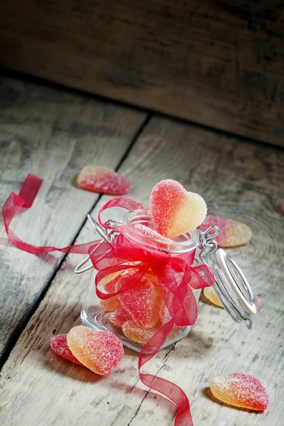Fruit jelly candy roze en gele harten in een glazen pot — Stockfoto