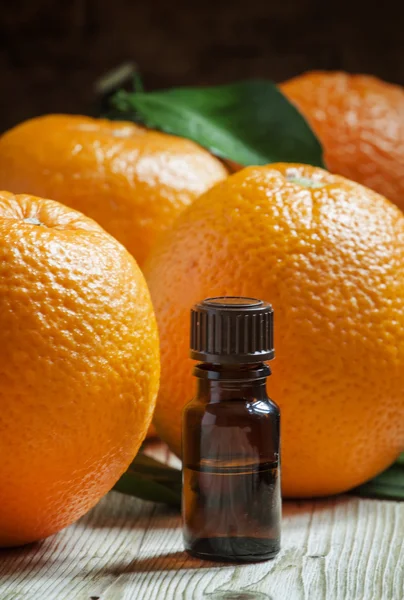 Óleo de laranja em uma pequena garrafa e frutas frescas — Fotografia de Stock