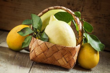 Hasır sepet içinde yapraklarla taze limon  