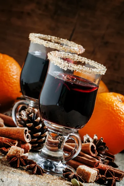 Муглированное вино в больших бокалах, специях, апельсинах и еловых шишках — стоковое фото