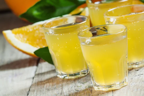 Апельсиновая сода на фоне свежих апельсинов — стоковое фото