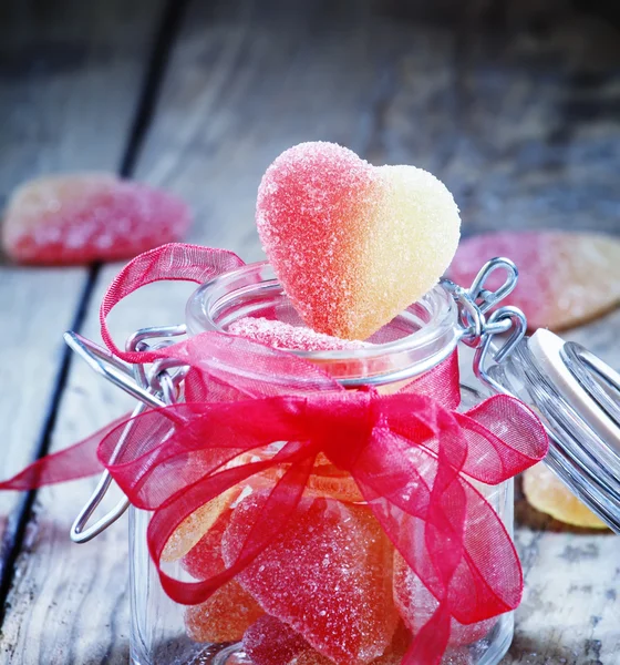 Fruit jelly pink and yellow candy hearts in a glass jar — Stock Photo, Image