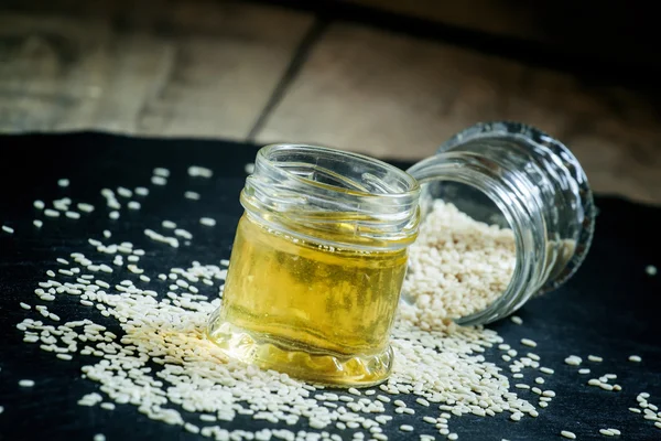 Aceite de sésamo en la olla y semillas de sésamo espolvoreadas — Foto de Stock