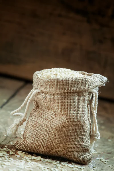 Sementes de gergelim branco em saco de serapilheira — Fotografia de Stock