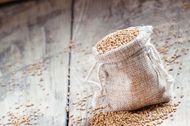 Tahıl çul eski ahşap masa üzerinde bir torba hardal