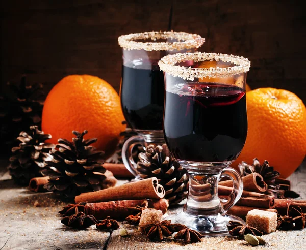 Vino rimuginato in grandi bicchieri, spezie, arance e coni di abete — Foto Stock