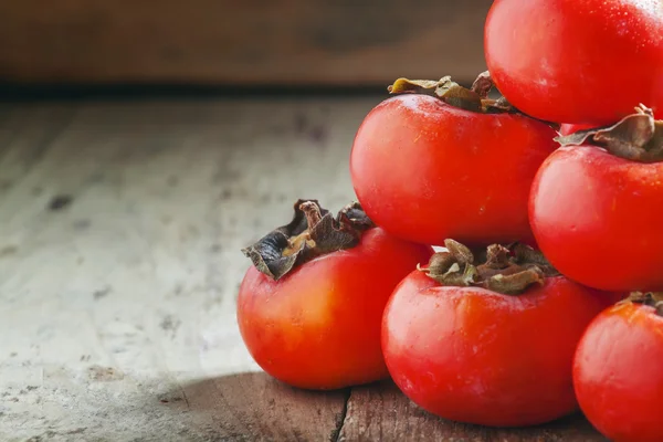 Turuncu persimmons bir piramit şeklinde yığılmış — Stok fotoğraf