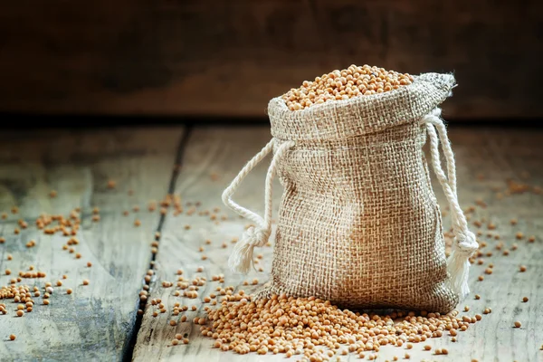 Senape di grano in un sacchetto di sacco sul vecchio tavolo di legno — Foto Stock