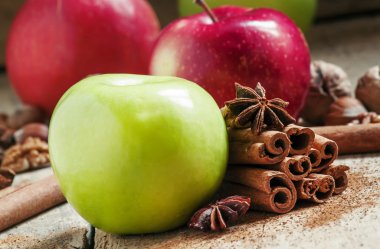 Fresh red and green apples, cinnamon sticks, ground cinnamon, anise stars