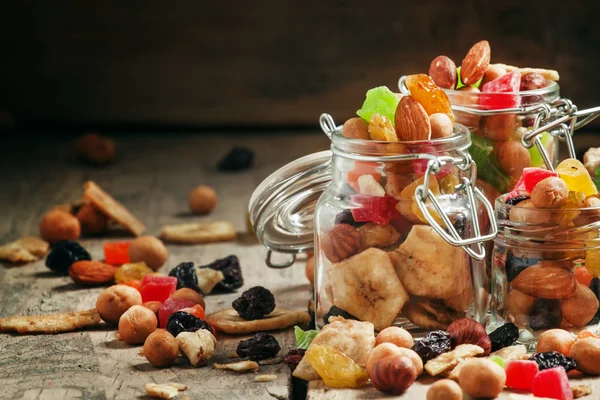 Nuts and dried fruits in glass jars — Stock Photo, Image