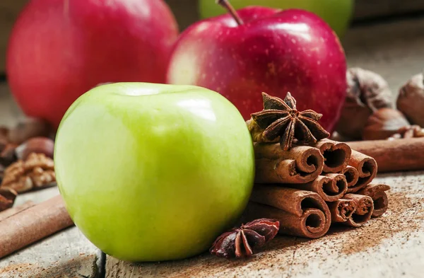 Fresh red and green apples, cinnamon sticks, ground cinnamon, anise stars