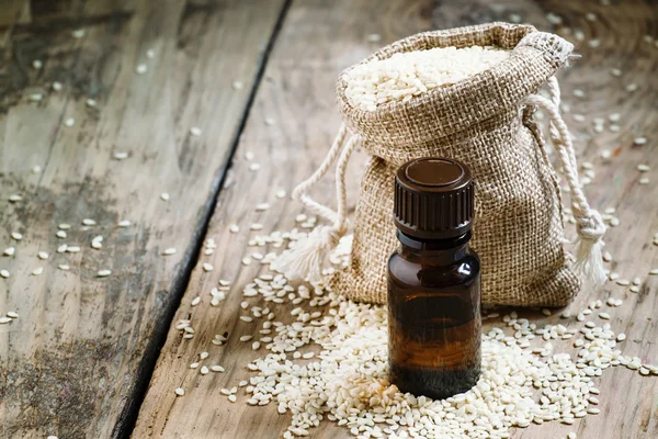 Ätherisches Sesamöl in einer Flasche aus braunem Glas und Sesam — Stockfoto