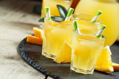 Turuncu içecek çizgili payet ve sürahi ile küçük bardaklarda