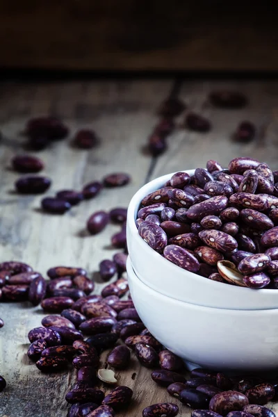 Purple-brown dry beans in a white porcelain bowl