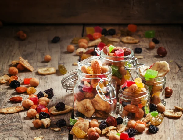 Nuts and dried fruits in glass jars — Stock Photo, Image
