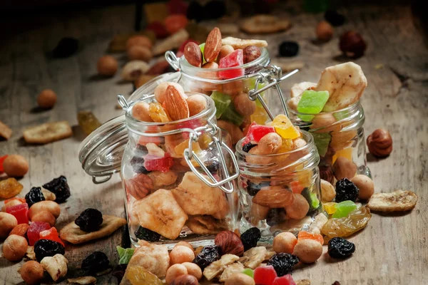 Nuts and dried fruits in glass jars — Stock Photo, Image