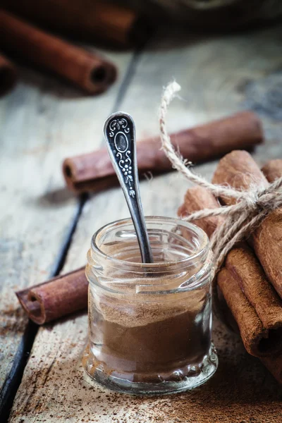 Canela moída em um frasco de vidro com uma colher — Fotografia de Stock