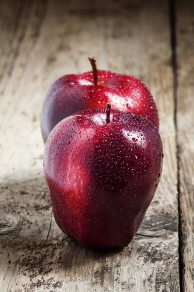 Красное и бургундское яблоко с каплей воды — стоковое фото
