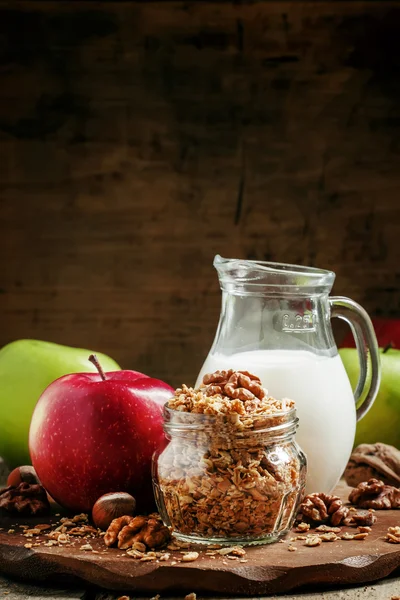 Baked muesli with nuts, milk jug, green and red apples — Stockfoto