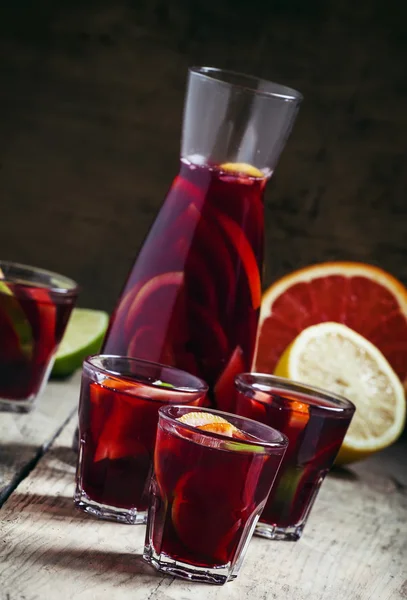 Sangria gyümölcs üvegek és egy régi fából készült háttér kancsó — Stock Fotó