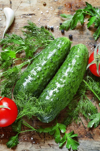 Verse komkommers, tomaten, dille en peterselie op de oude houten achtergrond — Stockfoto