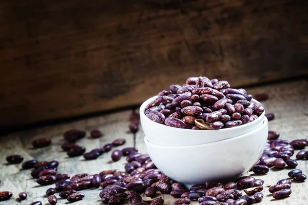 Purple-brown dry beans in a white porcelain bowl