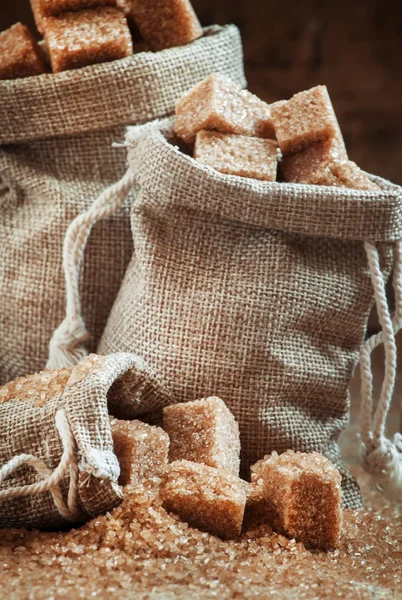 Caña de azúcar morena cubos y cristales en sacos de arpillera —  Fotos de Stock