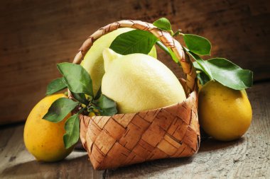 Hasır sepet içinde yapraklarla taze limon  