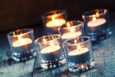 Burning small candles in glass candlesticks 